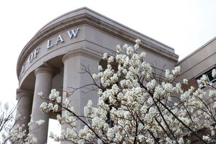 Front of the Law School Building with blooming flowers